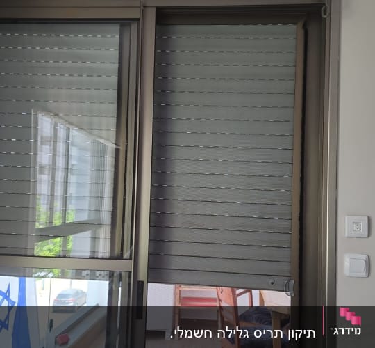 תריסים סגורים על חלון זכוכית עם מסגרת מתכת
